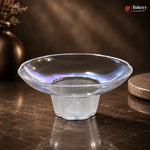 Clear glass bowl on a dark surface with a blurred background