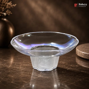 Clear glass bowl on a dark surface with a blurred background