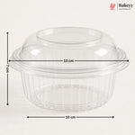 Clear plastic dome lid with a flared rim and ribbed base, shown with dimension arrows and labels indicating 13 cm width, 10 cm base diameter, and 7 cm height on a light gray background. Bakeyy logo appears in the top right.