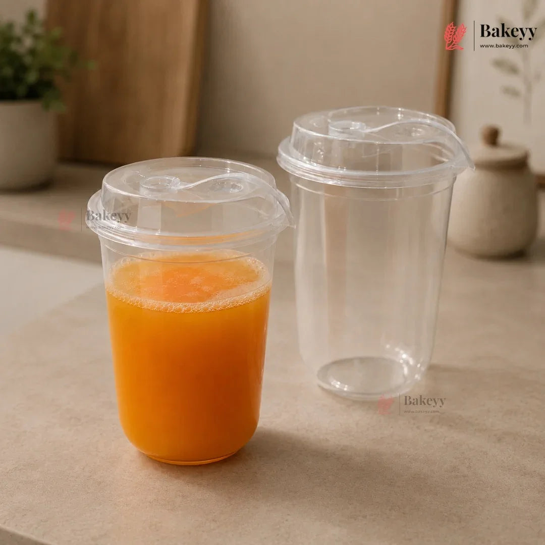 Clear plastic cups with orange juice on a beige surface, featuring the Bakeyy brand.