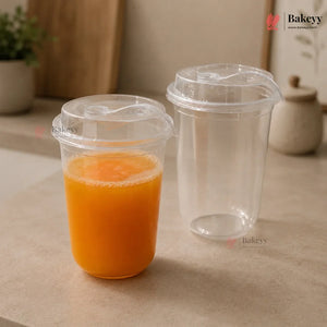 Clear plastic cups with orange juice on a beige surface, featuring the Bakeyy brand.