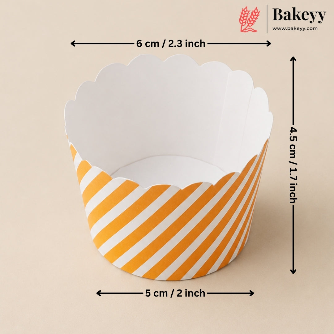 A scalloped paper cupcake liner with yellow and white diagonal stripes, shown with dimension arrows indicating a width of 5 cm (2 inches), height of 4.5 cm (1.