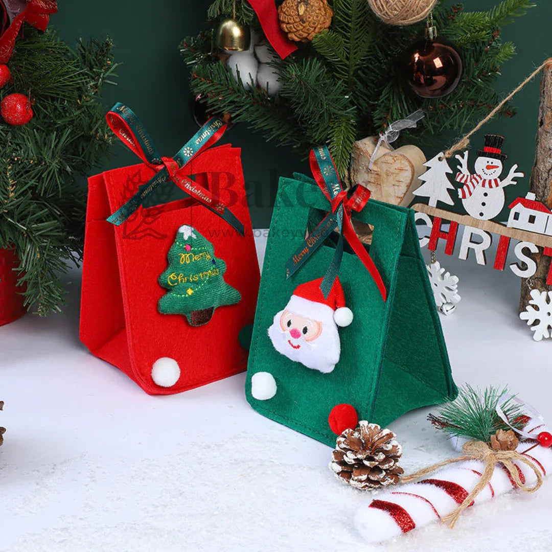 Two Christmas-themed gift bags with Santa Claus and Christmas tree designs, placed against a festive background.