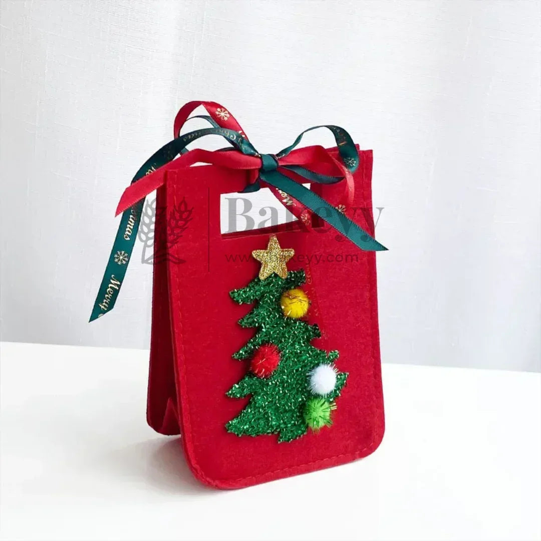 Red gift bag with green Christmas tree decoration and gold star on a white background