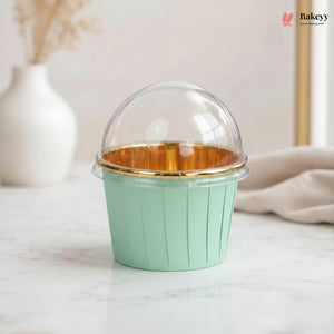 Green cupcake container with gold interior on a light surface, featuring the Bakey brand.