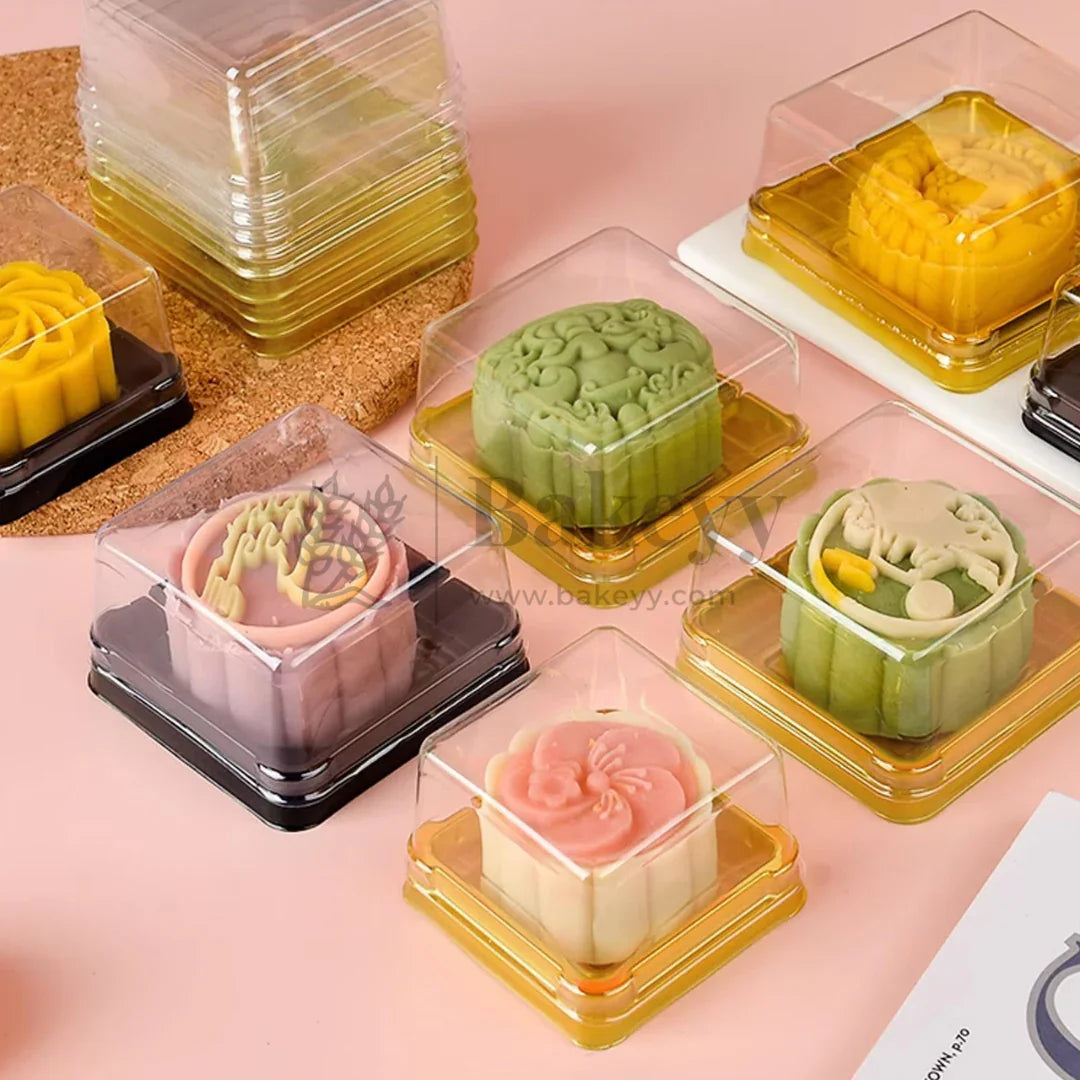 Assorted decorative cupcakes in clear square plastic bakery boxes from Bakeyy.com on display.