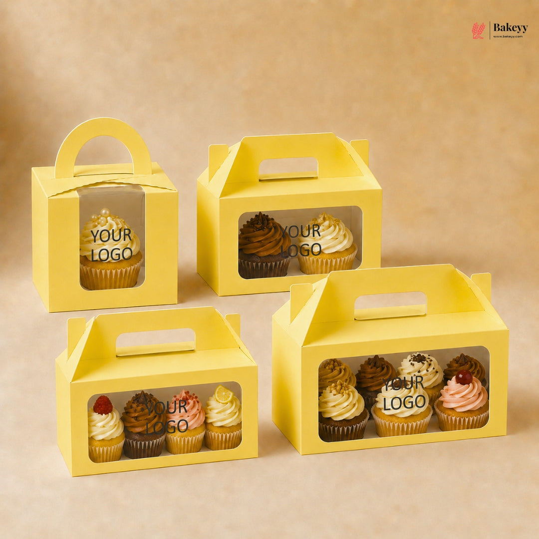 Yellow cupcake boxes with clear windows displaying cupcakes on a beige background