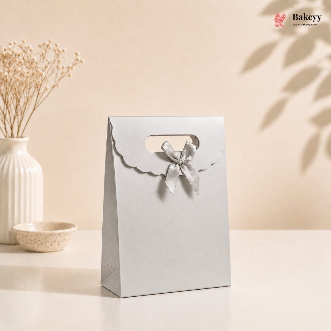 White gift bag with a bow on a beige background, featuring the Bakey brand.