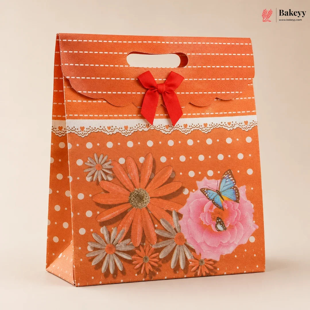 Decorative orange gift bag with floral designs and a red bow on a beige background