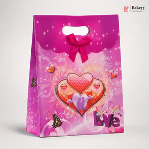 Pink gift bag with heart design and 'Love' text on a white background