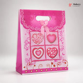 Pink gift bag with heart designs on a white background