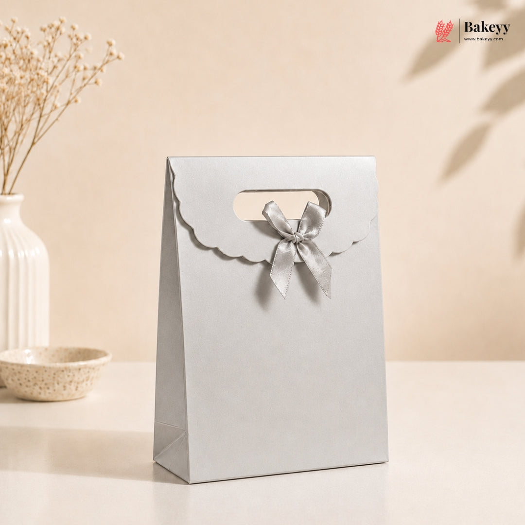 White gift bag with a bow on a beige background, featuring the Bakey brand.