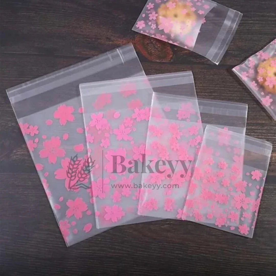 Clear plastic bags with pink floral designs and 'Bakeyy' branding on a dark surface.