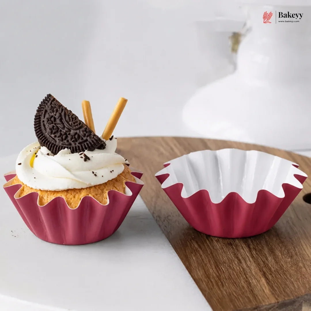 Red silicone cupcake mold with a decorated cupcake and white background