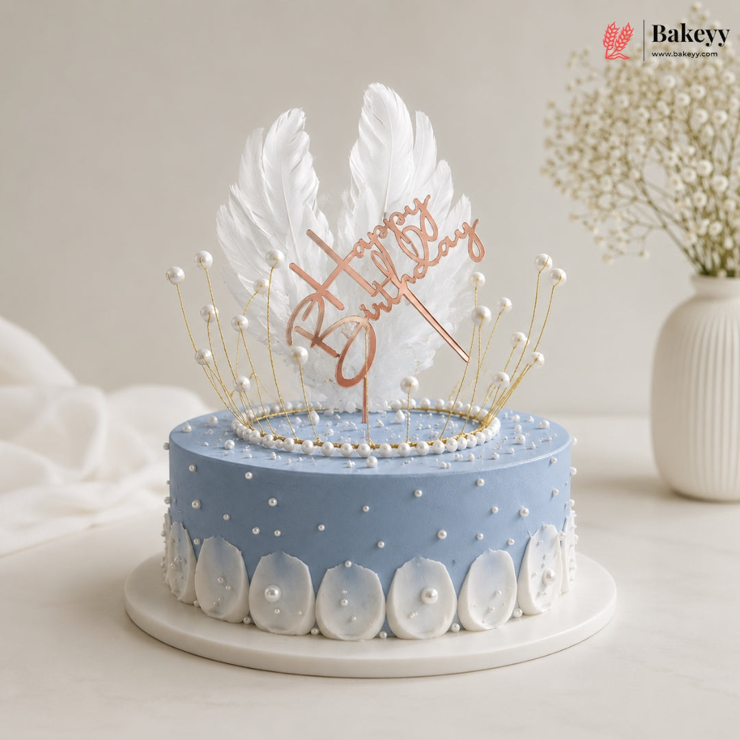 Decorative cake with feather topper and 'Happy Birthday' text on a light background
