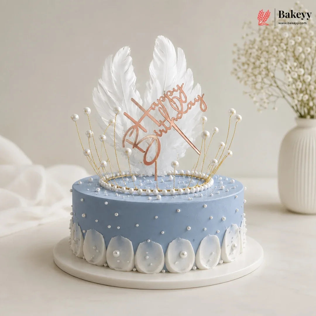 Decorative cake with feather topper and 'Happy Birthday' text on a light background