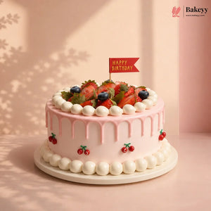 Pink birthday cake with fruit decorations and a 'Happy Birthday' flag on a light pink background.