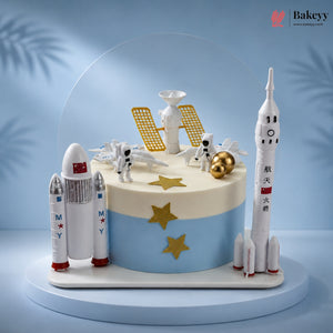 Space-themed cake with rocket models and astronaut figures on a blue background
