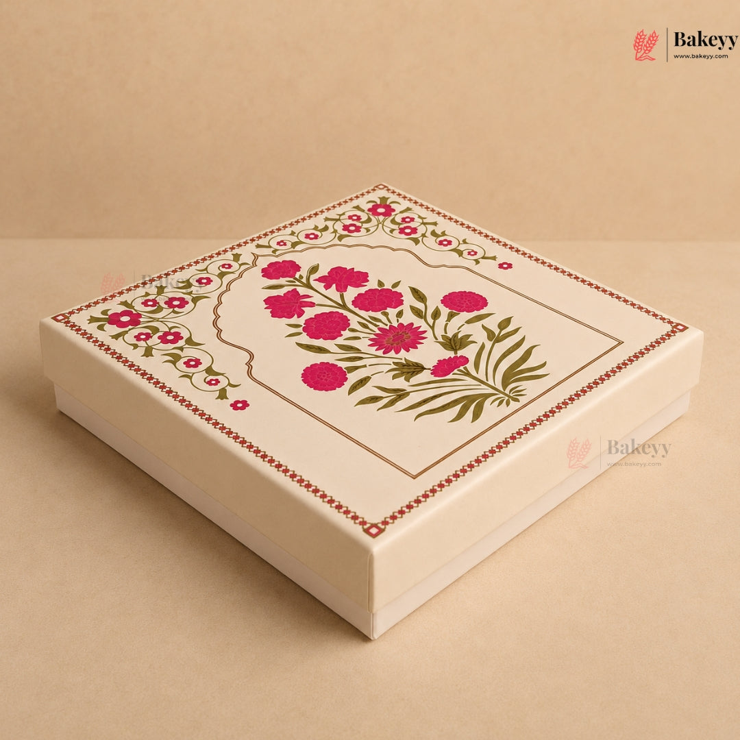 A square cream-colored bakery gift box with a lid decorated with a pink floral design and green leaves, set against a matching beige background.
