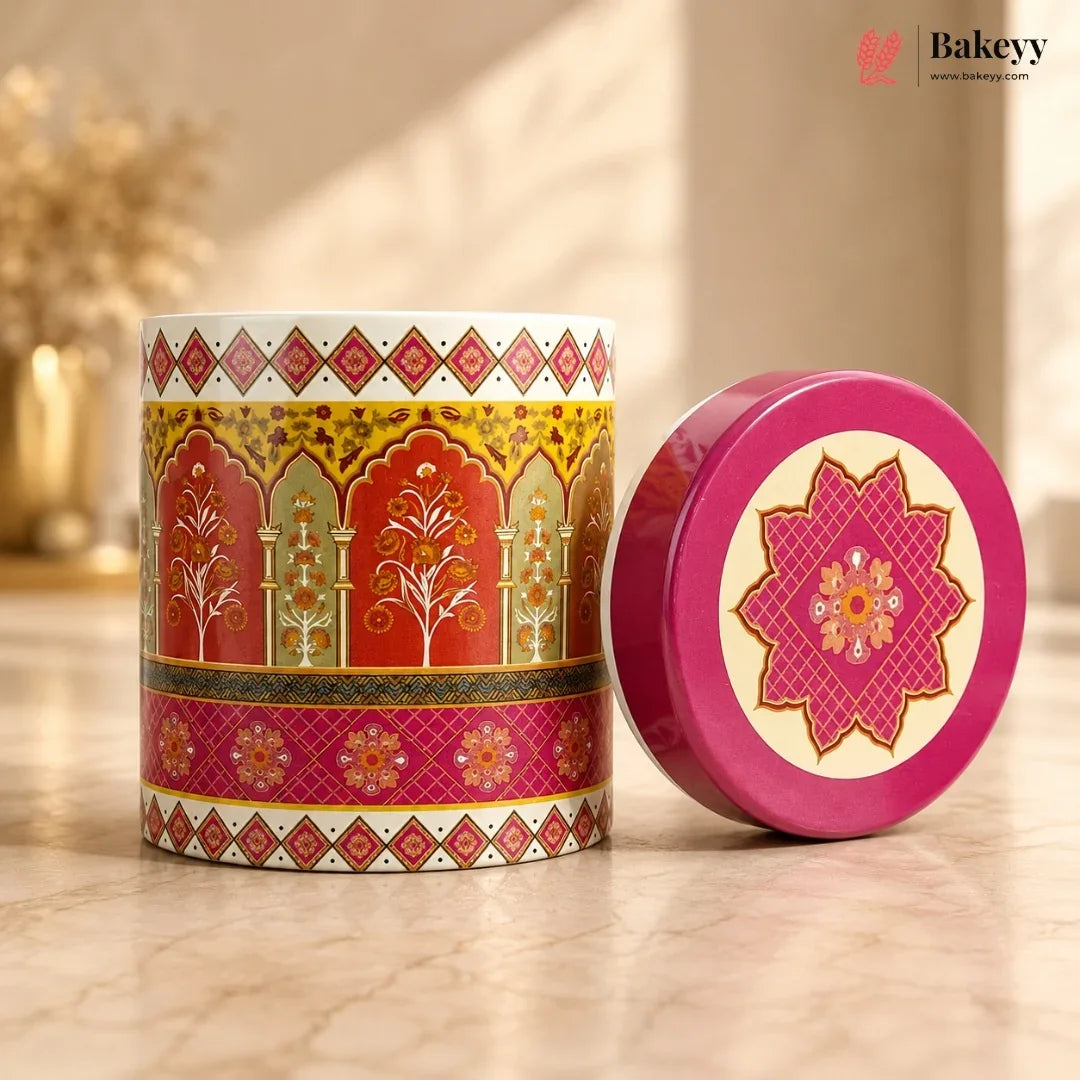 Decorative tin can with a pink lid featuring intricate patterns on a wooden surface.