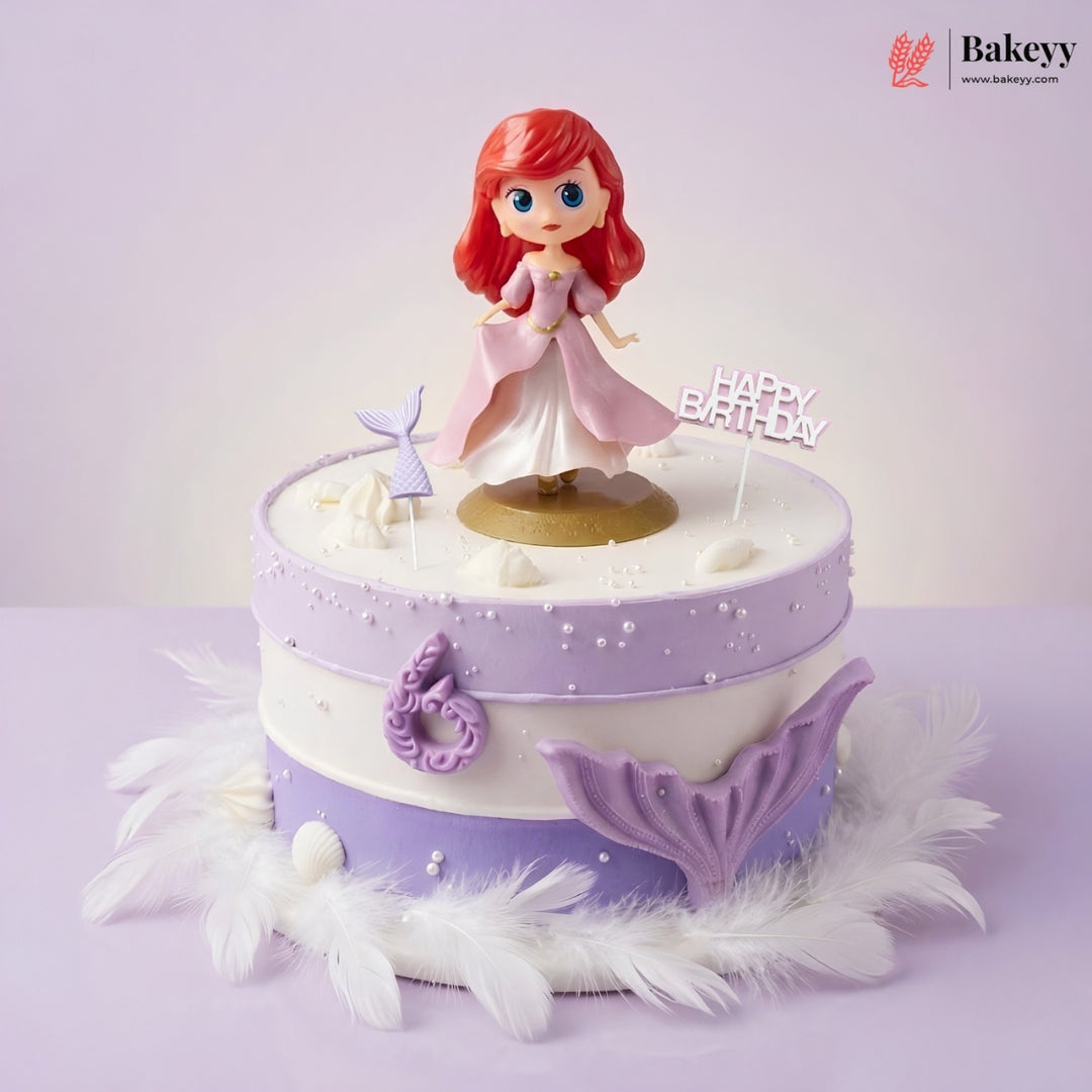 Decorative cake with a mermaid figurine and 'Happy Birthday' topper on a light purple background.