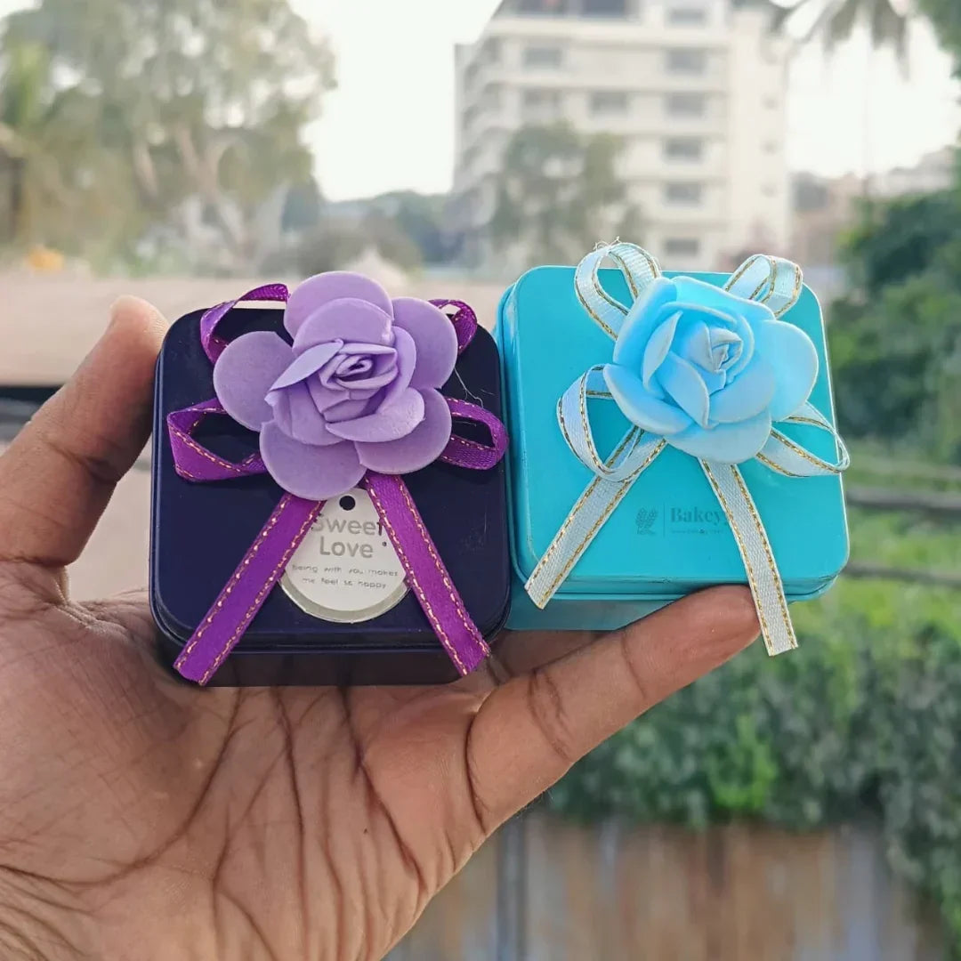 Decorative metal tin gift boxes with ribbon flowers by Bakeyy, perfect for packaging gifts.