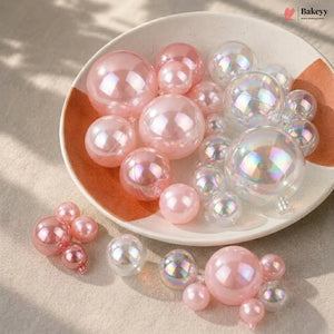 Pink and clear bubble-like objects on a white plate with a beige background