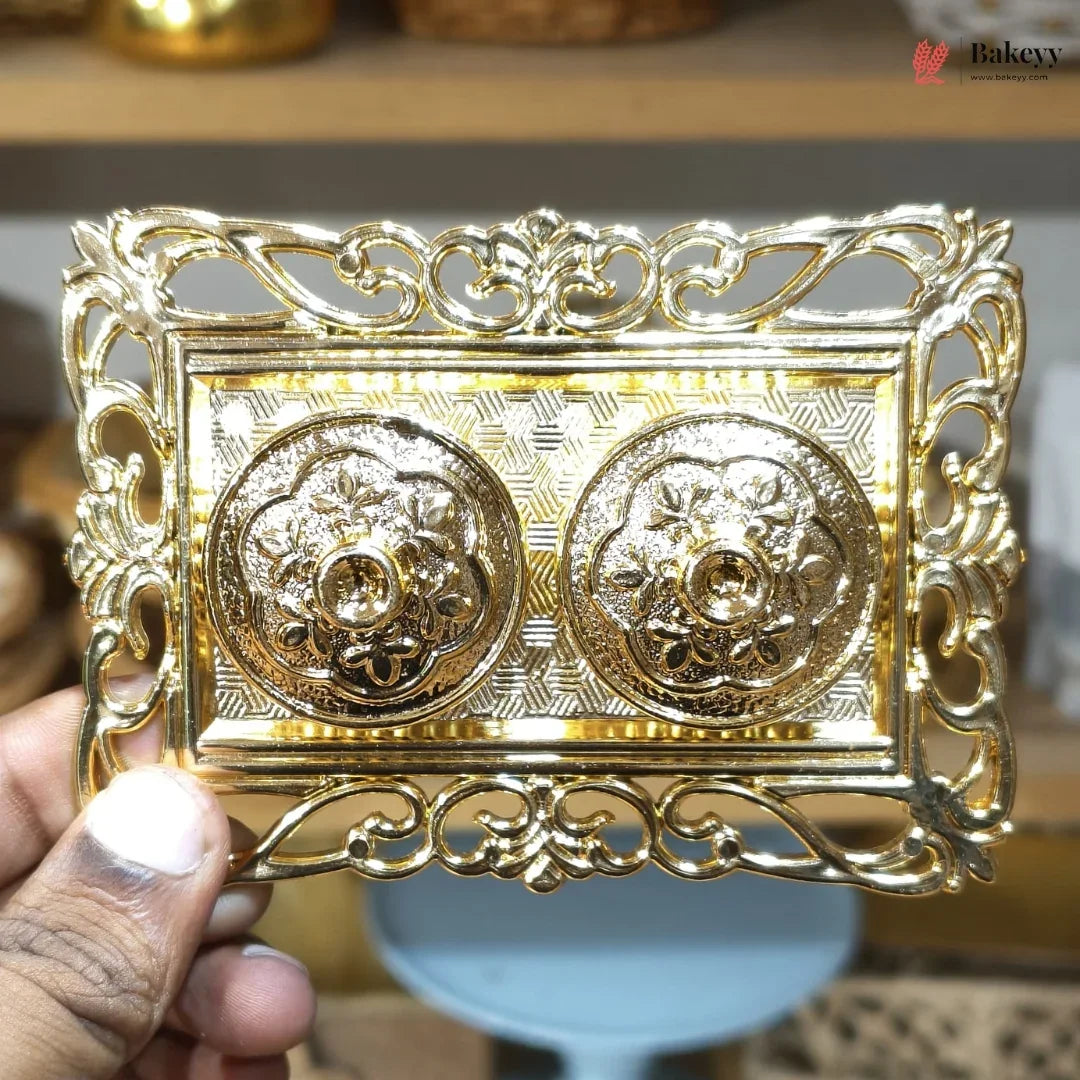 Decorative gold metal box held by a hand with a blurred background
