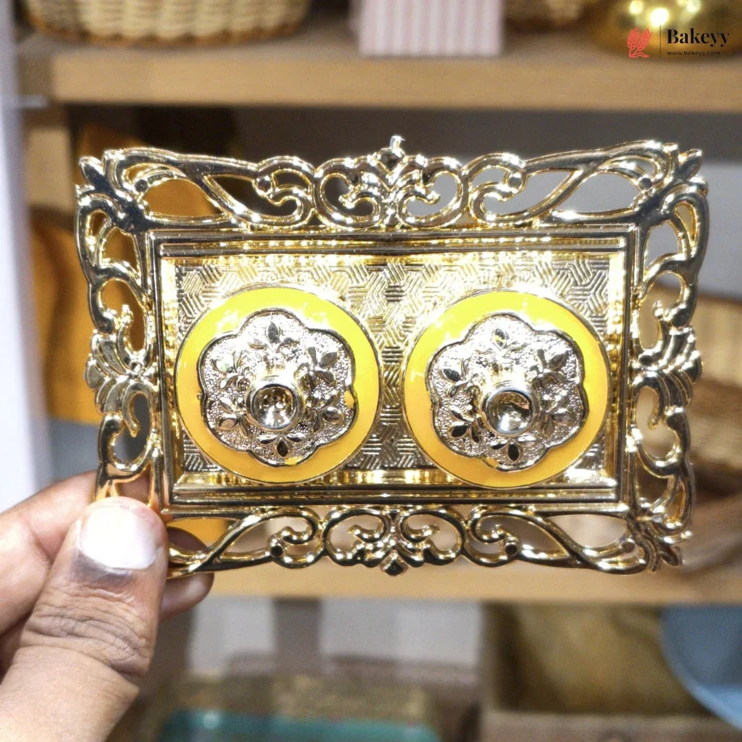 Decorative gold frame with intricate designs held by a hand.