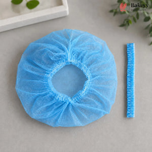 A light blue disposable non-woven bakery sleeve shown next to its blue elastic trim, on a neutral gray background with decorative green leaves.