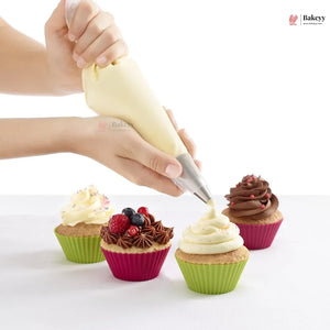 Person decorating cupcakes with a piping bag on a white background, featuring the Bakey brand.
