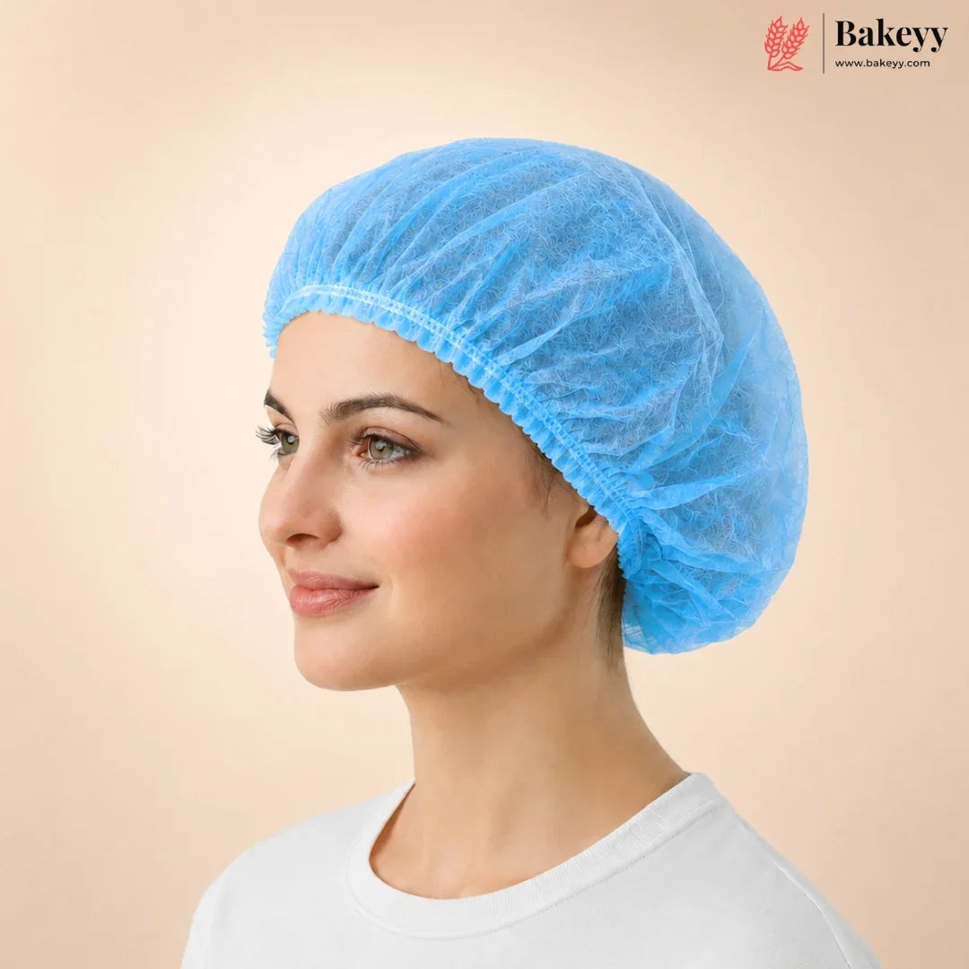 A woman in profile wearing a light blue disposable paper food cover cap, shown against a solid beige background with the Bakeyy brand logo in the top right corner.
