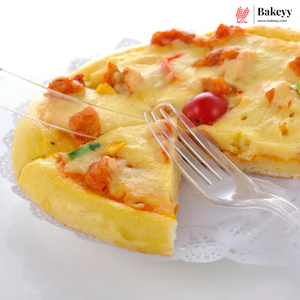 A close-up of a baked pizza with melted cheese, tomato pieces, and small vegetable bits on a white plate, with a clear plastic fork and knife and a Bakeyy logo in the top right corner.