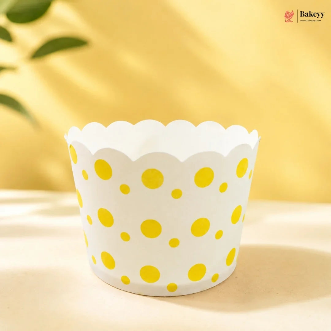 White cupcake liner with yellow polka dots on a yellow background