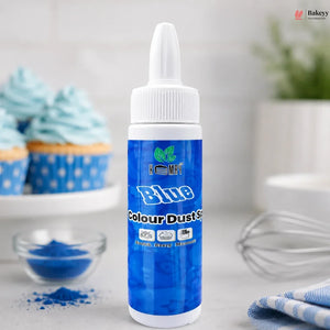 Bottle of blue food color with cupcakes and a whisk in the background