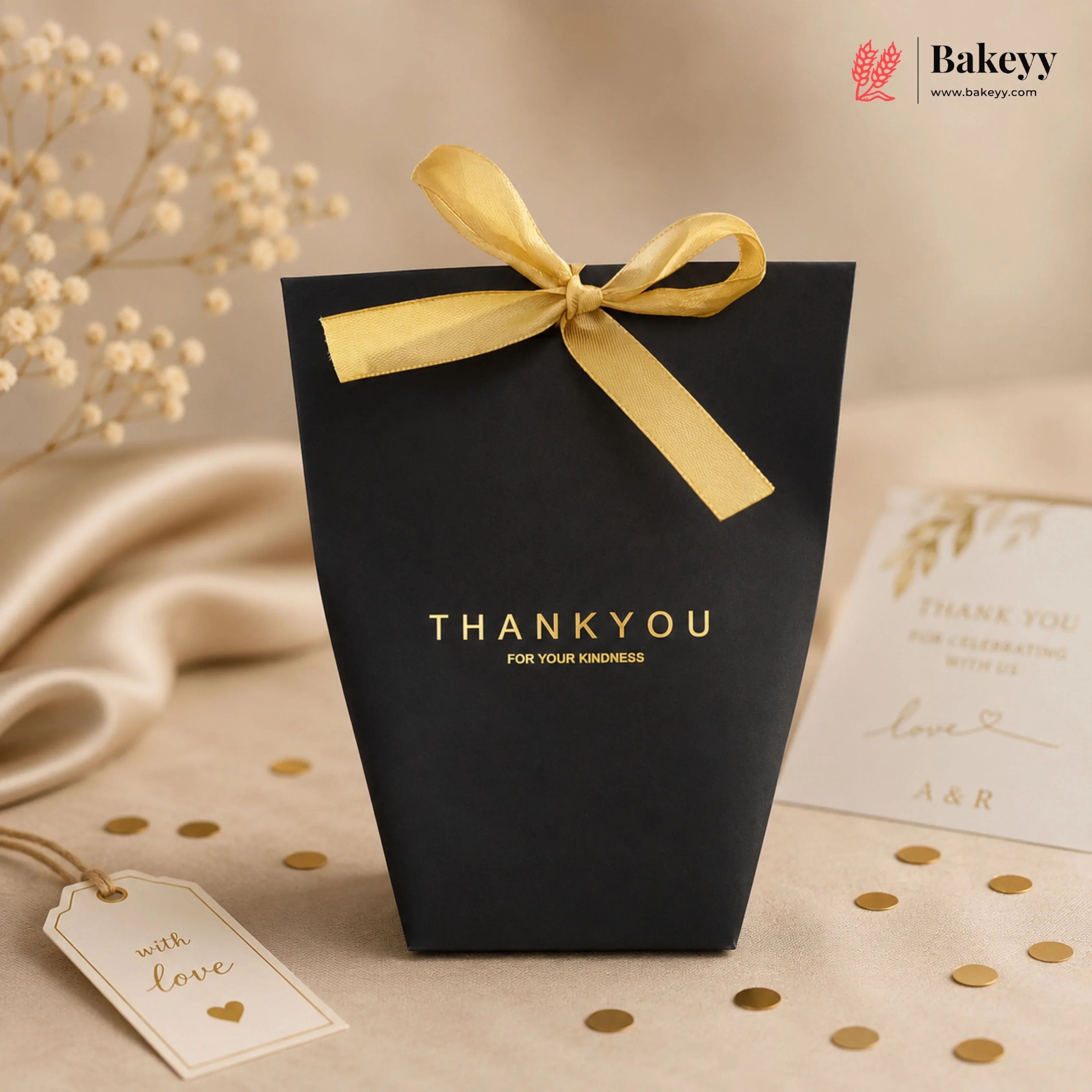 Black gift bag with yellow ribbon and 'THANK YOU' text on a beige background with decorative elements.