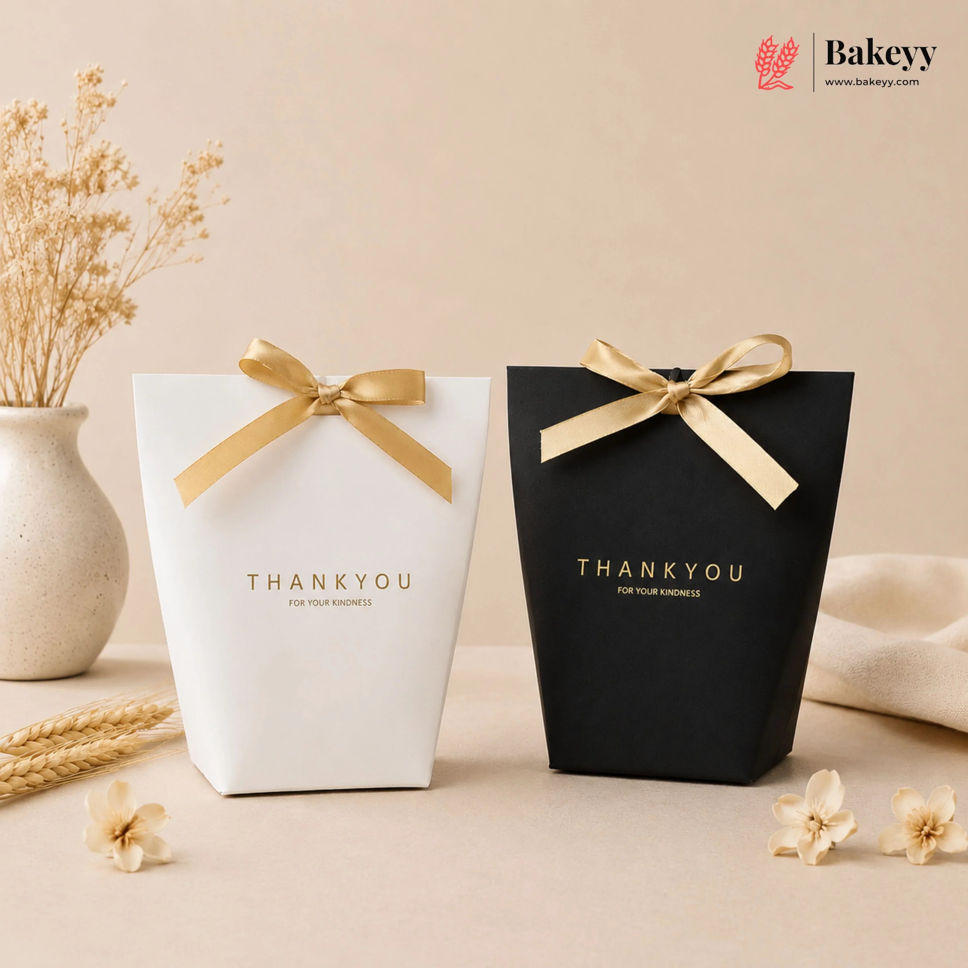 Two gift boxes, one white and one black, with gold ribbons and 'THANKYOU' text on a beige background.