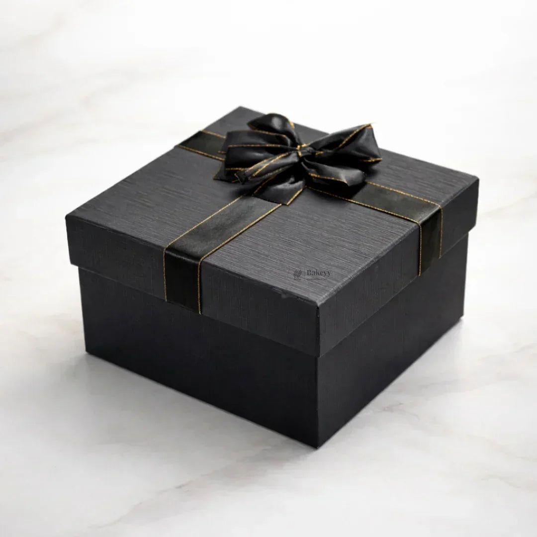Elegant black gift box with gold trim ribbon on marble background, Bakeyy gift packaging
