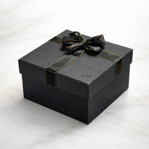 Elegant black gift box with gold trim ribbon on marble background, Bakeyy gift packaging