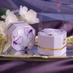 Decorative purple and gold boxes with floral patterns on a reflective surface.