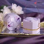 Decorative purple and gold boxes with floral patterns on a reflective surface.