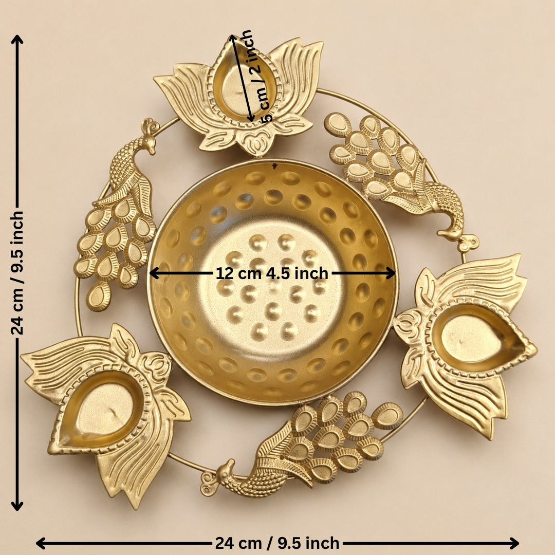 Gold-toned brass Diya holder with peacock and lotus motifs, shown with dimension markings indicating a height and width of 24 cm (9.5 inches) and a central diameter of 12 cm (4.
