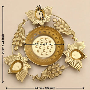 Gold-toned brass Diya holder with peacock and lotus motifs, shown with dimension markings indicating a height and width of 24 cm (9.5 inches) and a central diameter of 12 cm (4.