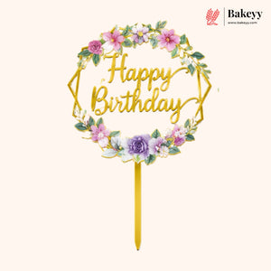 Gold 'Happy Birthday' cake topper with floral decorations on a white background, featuring the brand 'Bakeyy'.