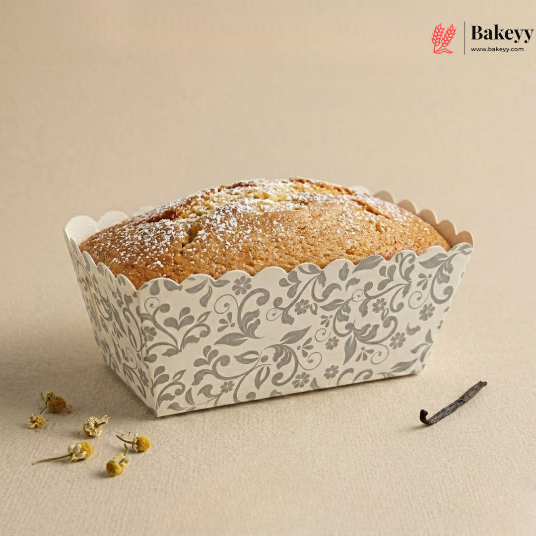 Loaf of bread in a decorative paper container on a beige background with 'Bakeyy' branding.