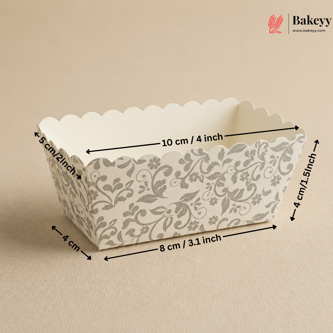 Decorative paper loaf pan with floral pattern and measurements on a beige background, featuring the Bakeyy brand.