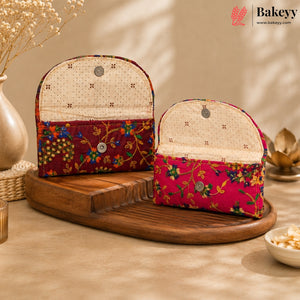 Two fabric pouches with floral printed lower sections and cream dotted interiors, displayed on a wooden tray in a warm styled setting. The Bakeyy brand logo appears in the top right corner.