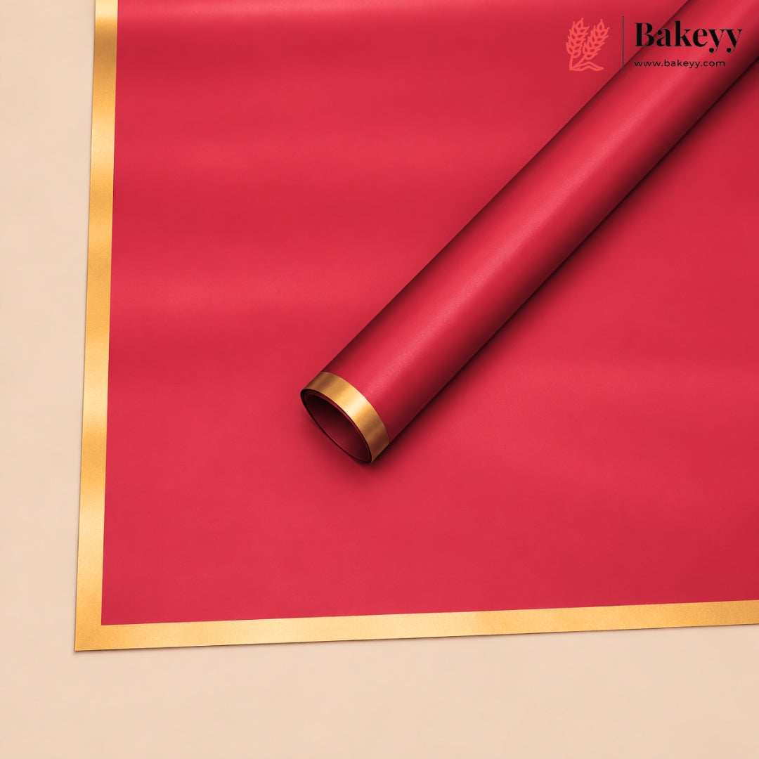 A roll of red bakery paper or wrapping paper with a metallic gold border, shown diagonally on a beige background. The Bakeyy brand logo is visible in the top right corner.