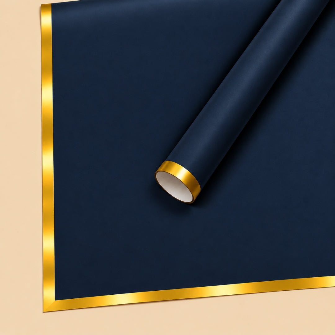 A roll of dark navy blue wrapping paper with a metallic gold border, shown partially unrolled on a light beige background.