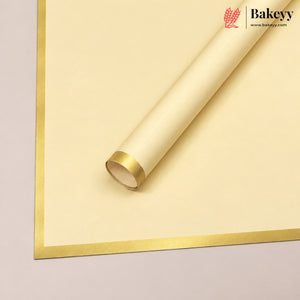 A roll of cream-colored bakery paper with a metallic gold border, shown partially unrolled on a light gray background. The Bakeyy brand logo is visible in the top right corner.